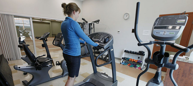 Image of a community member using the tread mill in the Harvey and Anne West Fitness Room within the Veteran's Memorial Hall.