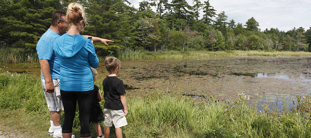 Image of a family stopped along one of the trails to look out into the water.